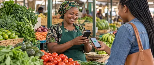 Market trader receiving a mobile payment at her produce stall